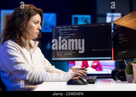 System administrator fixing vulnerabilities in software enabling hackers to compromise operating system. Cybersecurity specialist in apartment using computer to patch security exposures Stock Photo