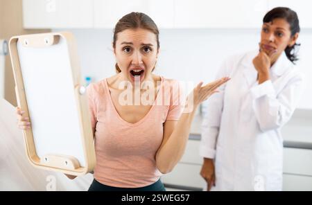 Dissatisfied woman checking result after cosmetology procedure Stock Photo