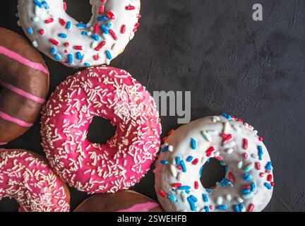 Colorful donuts on black stone table. Top view Stock Photo