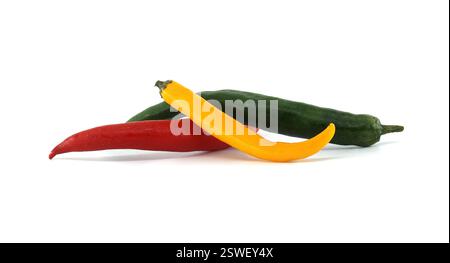 Three vibrant chili peppers in red, green, and yellow resting on a white background, creating a striking and colorful arrangement that highlights thei Stock Photo