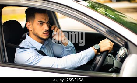 Angry arabic guy manager fighting on phone while driving auto Stock Photo