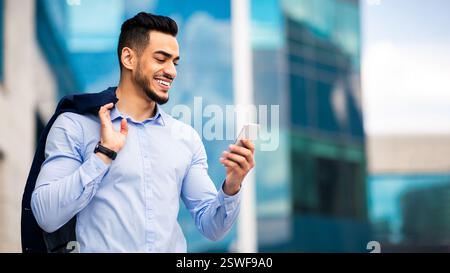 Middle-eastern young entrepreneur checking emails on smartphone Stock Photo