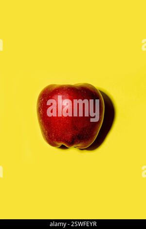 Red apple on a solid yellow background Stock Photo