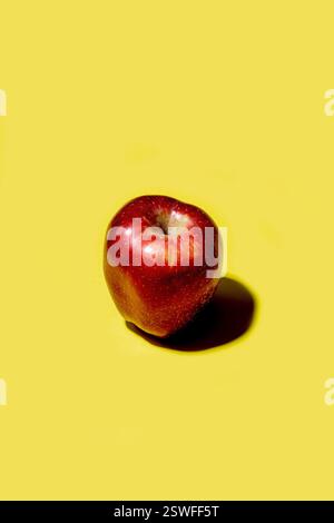 Red apple on a solid yellow background Stock Photo