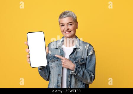 Great App. Smiling Mature Lady Pointing At Smartphone With Black Screen Stock Photo