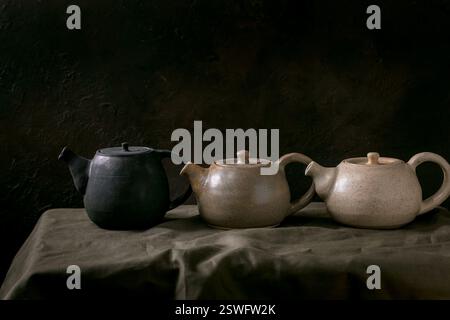 Set of craft handmade ceramic teapots with dark background Stock Photo