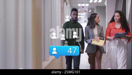 Image of media icons over diverse colleagues discussing work and walking in office Stock Photo