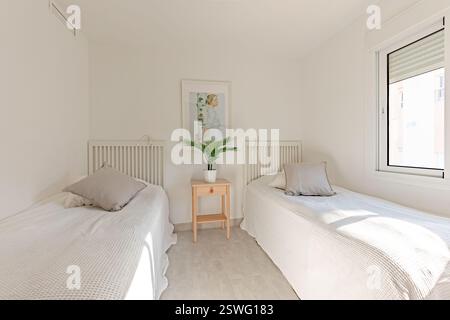 an image of two single beds with cushions in mediterranean holiday home Stock Photo