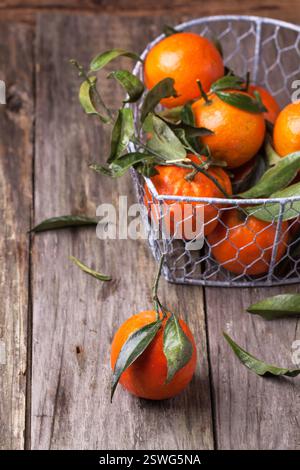 Tangerines with leaves on wooden background Stock Photo