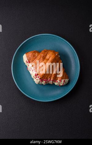 Crispy sweet red croissant with pistachio, raspberry and strawberry Stock Photo