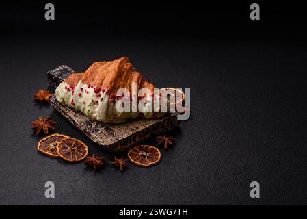Crispy sweet red croissant with pistachio, raspberry and strawberry Stock Photo