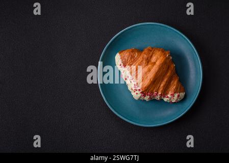 Crispy sweet red croissant with pistachio, raspberry and strawberry Stock Photo