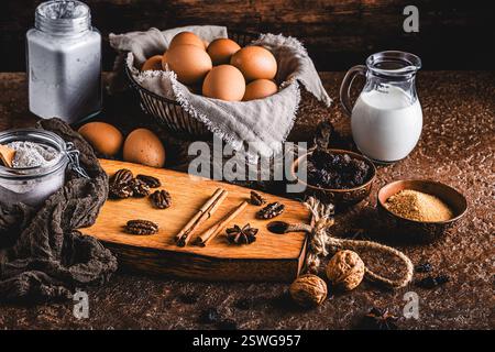 Assorted baking ingredients on wooden vintage table, brown colors. Preparation for home baking. Stock Photo