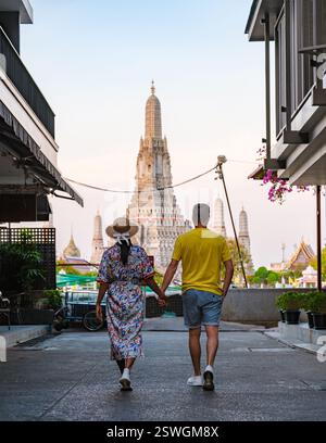 Couple Strolling Hand in Hand Towards Wat Arun in Bangkok, Thailand at Sunset Stock Photo