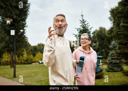 A loving couple walks hand in hand, sharing laughter and warmth in a serene park setting. Stock Photo