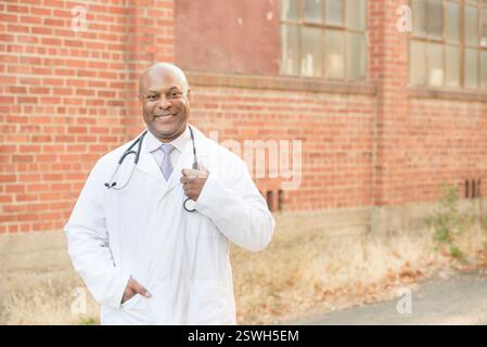 Smiling doctor in a white coat standing confidently Stock Photo