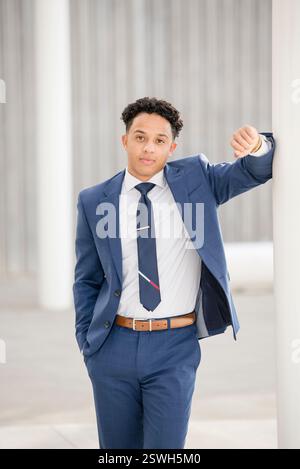 Professional man leaning against pole Stock Photo