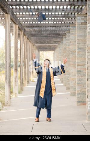 College graduate throwing cap in the air Stock Photo