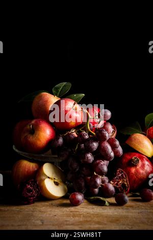 Apples, grapes and pomegranates on a black background Stock Photo