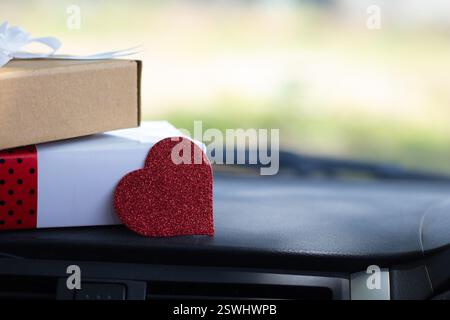 White and brown gift box with red heart placed on the car dashboard, valentine's day, women's day and mother's day concept Stock Photo
