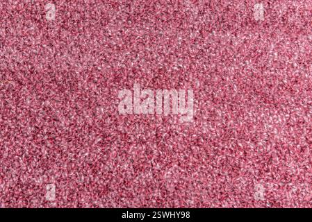 Textured background Close up of pink homemade knitted fabric with large stitches. Stock Photo