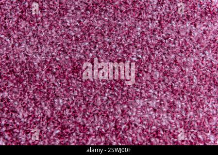 Textured background Close up of pink homemade knitted fabric with large stitches. Stock Photo