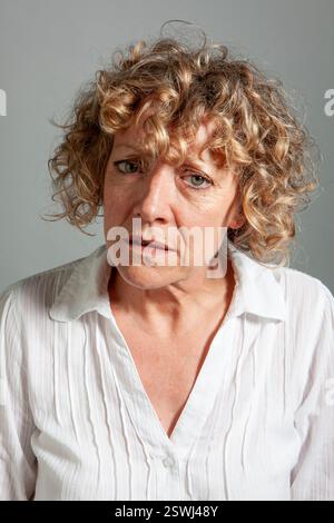 Mature Expressions: Quizzical. From a series of expressive portrait images of a mature female model, studio shoot. Stock Photo