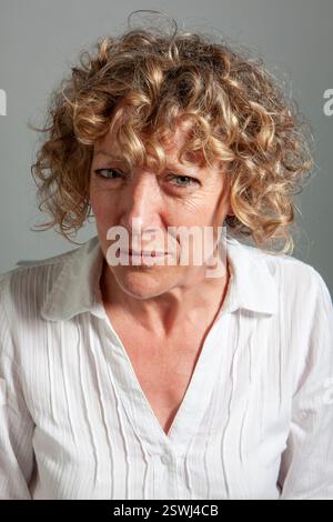 Mature Expressions: Suspicious. From a series of expressive portrait images of a mature female model, studio shoot. Stock Photo