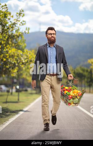 Bearded man with a basket full of fruits and vegetables showing thumbs ...