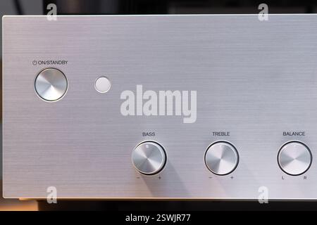 Detailed view of an audio amplifier's control knobs for bass, treble, and sound balance. The metallic surface complements the precision layout, reflec Stock Photo