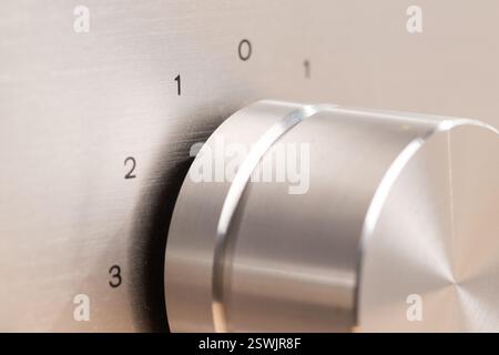 Detailed view of a shiny metal control knob on a device, with engraved markings for adjustable settings. Ideal for showcasing technology, precise adju Stock Photo