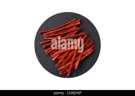Jerky dried fish sticks with salt and spices on a white background Stock Photo