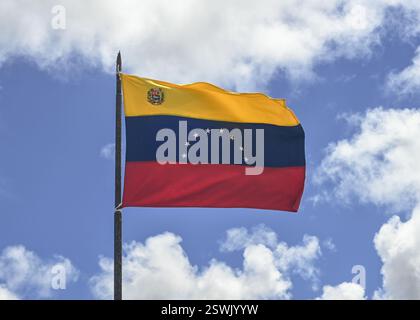 Venezuelan national flag waving against blue sky and white clouds Stock Photo