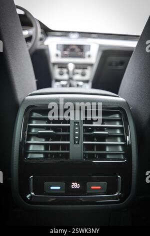 Rear passenger AC vents in a modern car interior Climate control display showing temperature Stock Photo