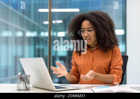 Angry and dissatisfied businesswoman looking at laptop screen. Employee received computer error and software failure Stock Photo