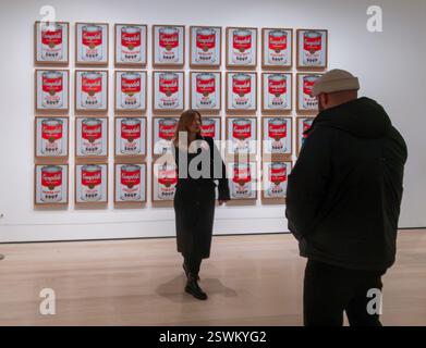 man photographing woman in front of Andy Warhol, Campbell's Soup Cans, 1962, The Museum of Modern Art, New York City, USA Stock Photo