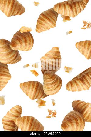 Delicious croissants and crumbs in air on white background. Puff pastry Stock Photo