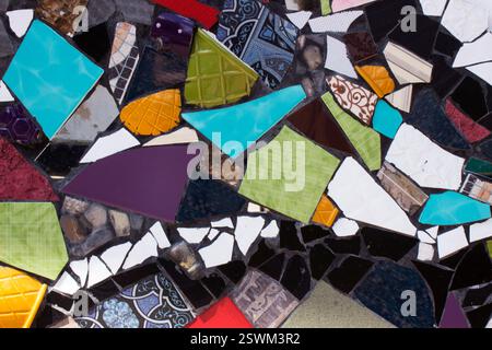Multicolored mosaic of broken plates, background. Slices of broken ceramic tableware Stock Photo