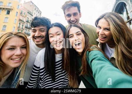 Happy multi-ethnic friends taking selfie in urban background Stock Photo