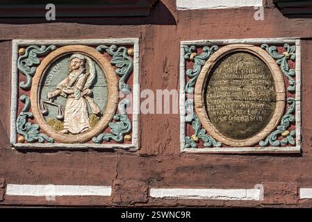 Colourfully painted carvings, medallions, relief for Justitia, goddess of justice, inscription on the half-timbered house Gasthaus Zum Goldenen Loewen Stock Photo