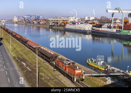 The port of Mannheim is one of Europe's most important inland ports and container terminals. Sea containers are stacked under gantry cranes waiting to Stock Photo