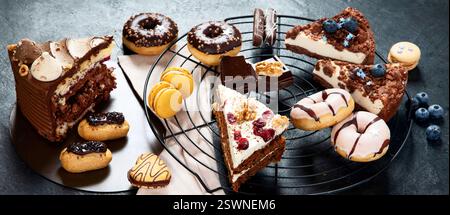 cookies, donuts, cakes, cheesecakes on dark background.  Delicious dessert table. Top view, flat lay Stock Photo