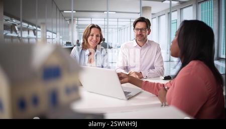 Professional couple discussing mortgage options with real estate agent Stock Photo