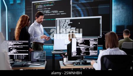 Team of diverse software engineers coding on desktop computers in office. Stock Photo