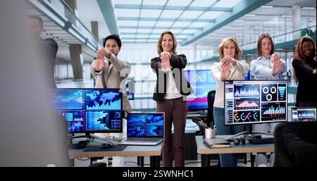 Office workers from different backgrounds practicing yoga at their desks. Stock Photo