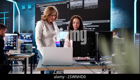 Creating cutting-edge technology in a late-night coding session, diverse team. Stock Photo
