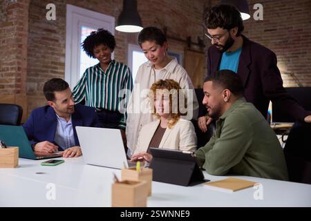 Marketing team working together on a project using laptop in the office Stock Photo