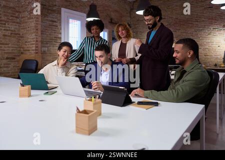 Marketing professionals collaborating on project in modern office Stock Photo