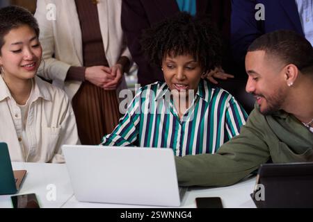 Diverse business team collaborating on project using laptop in office meeting Stock Photo