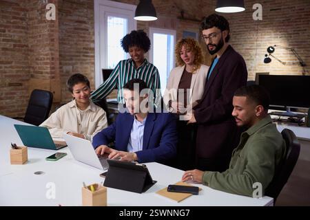 Marketing team working together on project using laptop in modern office Stock Photo